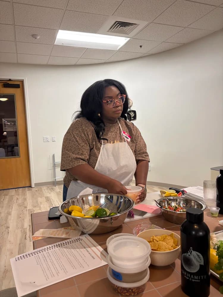 An adult cook works at a classroom prep station